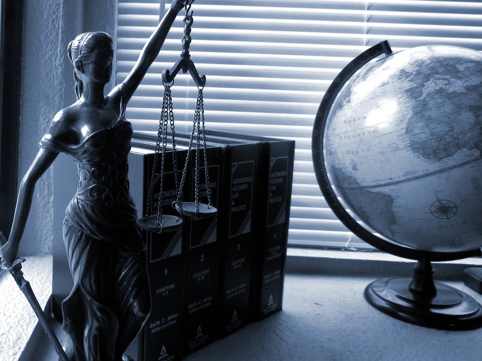 Attorney, lawyer or law professional's desk with law books, scales of justice and a globe.