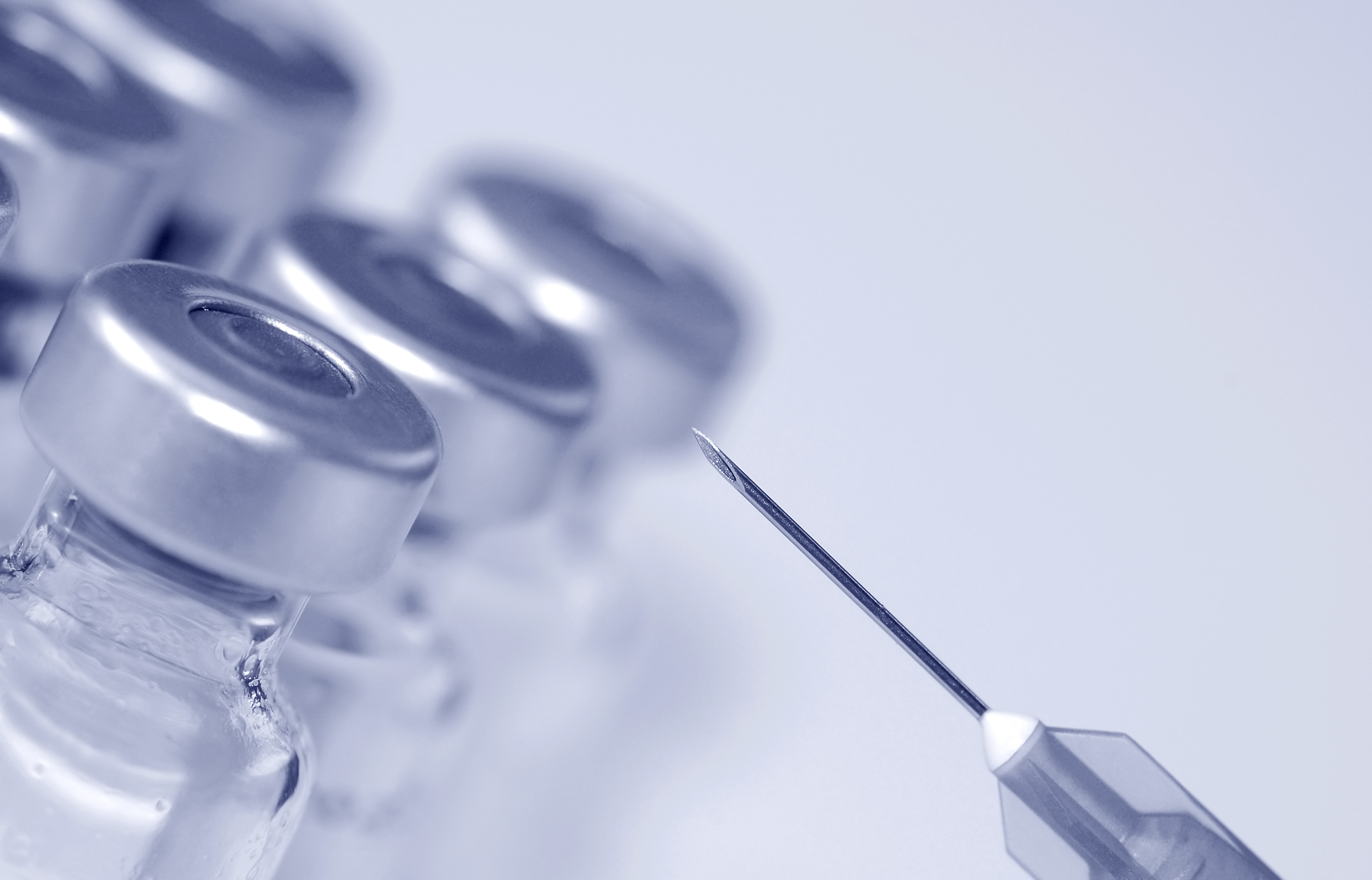close-up of syringe needle and glass phials