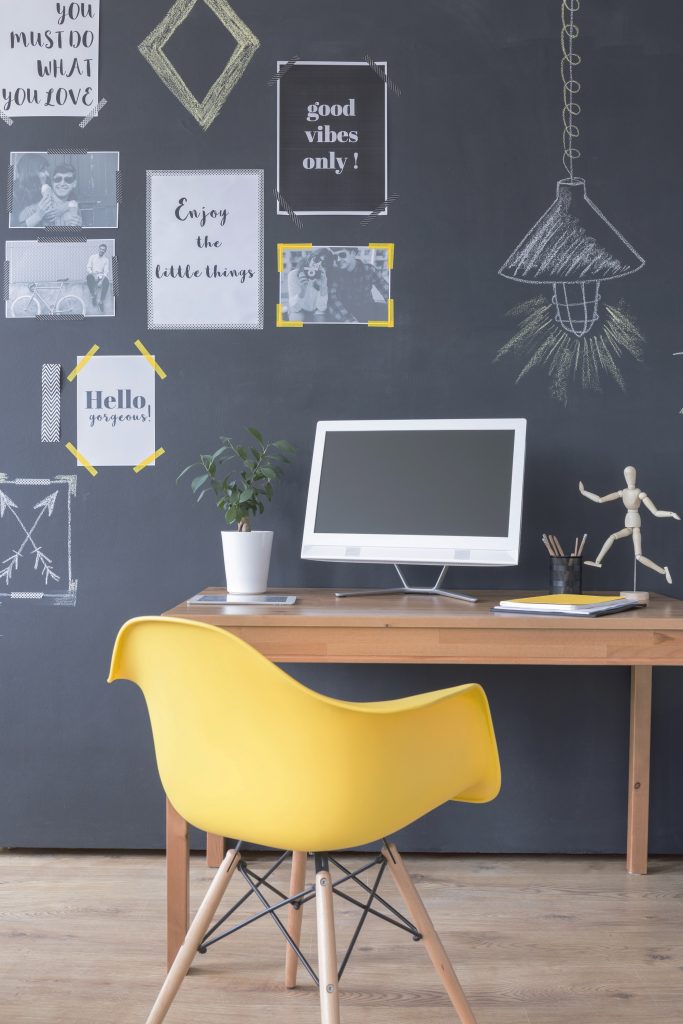 Cropped shot of an office interior with a minimalistic wooden desk and yellow chair