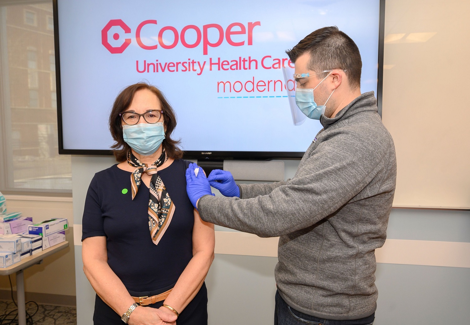 Dr. Annette Reboli receives her vaccination from medical student Nicholas Daroshefski.