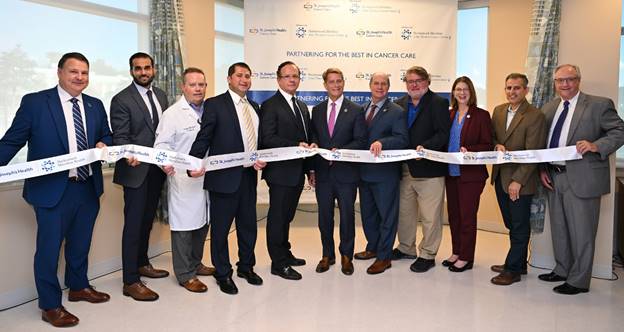 St. Joseph's Health and Hackensack Meridian Health celebrated the opening of a new Infusion Center on the campus of St. Joseph's Wayne Medical Center Sept 27, 2022, marking the first step of a more extensive oncology partnership that brings the expertise of Hackensack Meridian Health's John Theurer Cancer Center to residents of northern New Jersey. From left: Mark Sparta, president and chief hospital executive, Northern Region, Hackensack Meridian Health; Dr. Adnan Danish, chief, Division of Radiation Oncology, St. Joseph's Health; Dr. Joseph Duffy, chief medical officer, St. Joseph's Health; Dr. Stephan Dorkhom, chief, Department of Medicine, St. Joseph's Health; Dr. Andre Goy, chair and director of Hackensack Meridian John Theurer Cancer Center; Robert Garrett, CEO of Hackensack Meridian Health; Kevin Slavin, president and CEO of St. Joseph's Health; Christopher Vergano, mayor of Wayne; Jane White, vice president, Oncology, St. Joseph's Health; Dr. Sabin Motwani, medical director, Radiation Oncology, St. Joseph's Health; and Mark Stauder, president, Hospitals and Health Services Divisions, and chief operating officer, Hackensack Meridian Health.
