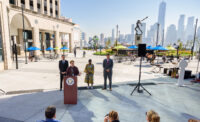 Exchange Place Alliance Director of Development and Operations Martin Schmid stands at the podium at the newly renovated pedestrian plaza, with the New York City skyline in the background. - EXCHANGE PLACE ALLIANCE