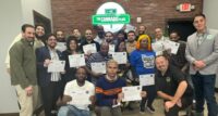 Graduates of a pre-apprenticeship program pose with Hugh Giordano, director of organizing at UFCW Local 360 (in black shirt, at right) and The Cannabis Place founder and CEO Osbert Orduna, in gray blazer.