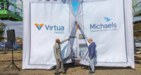 From left, Virtua Health President and CEO Dennis Pullin and The Michaels Organization CEO John O'Donnell open the "doors" Nov. 1 in Camden to reveal an oversized rendering of affordable housing and medical Oliver Station.