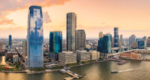 Aerial panorama of Jersey City skyline at sunset.