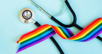 Stethoscope and LGBTQ rainbow ribbon pride symbol. Blue background — Photo