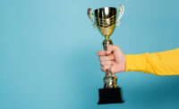Cropped view of man holding golden trophy on blue. - DEPOSIT PHOTOS
