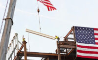 Construction crew members place the final beam in the Specialty and Cancer Care Pavilion at the Vogel Medical Campus in Tinton Falls.