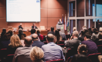 Audience in lecture hall participating at business event.